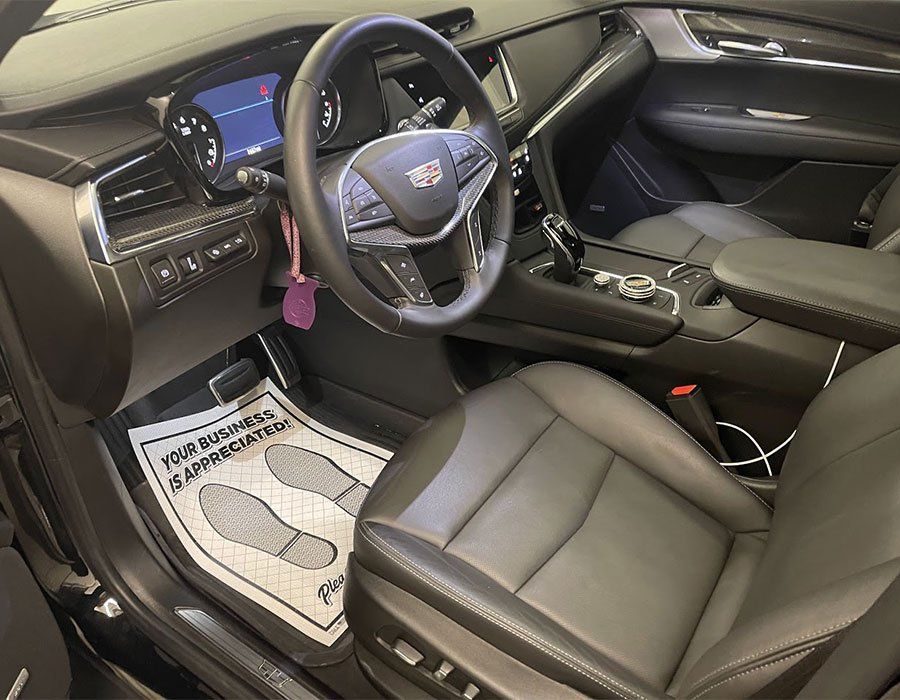The interior of a black car with a steering wheel and seats.