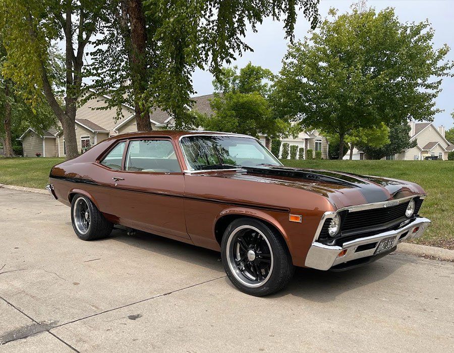 A brown car is parked on the side of the road.
