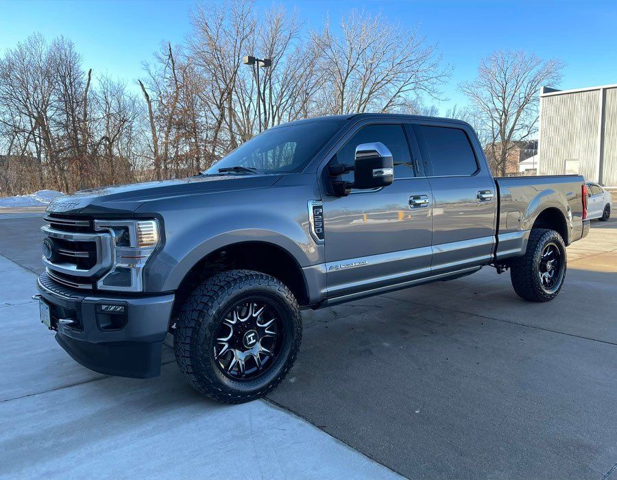 A gray ford f250 super duty truck is parked in a parking lot.