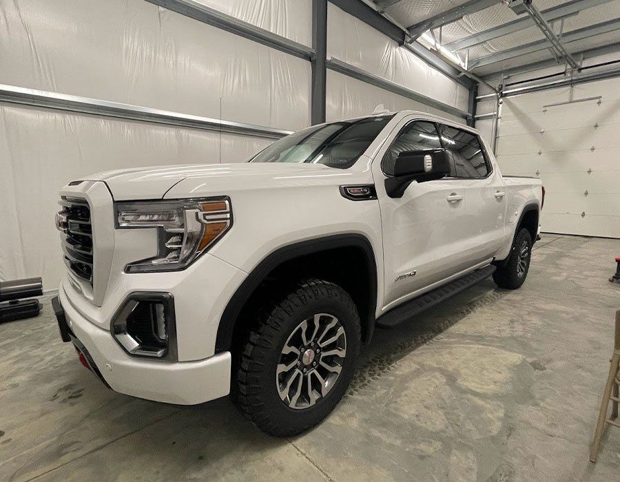A white pickup truck is parked in a garage.
