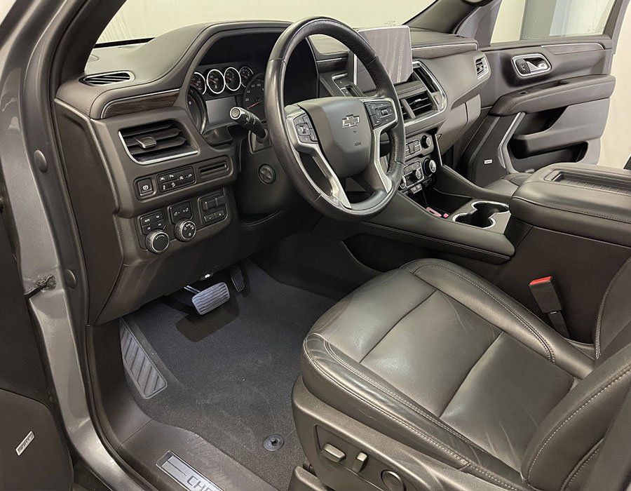 The interior of a car with leather seats and a steering wheel.