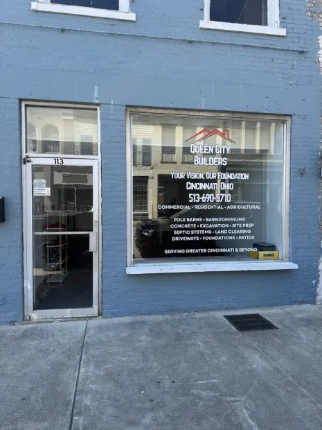 Blue storefront with a glass door and window displaying business hours and signage