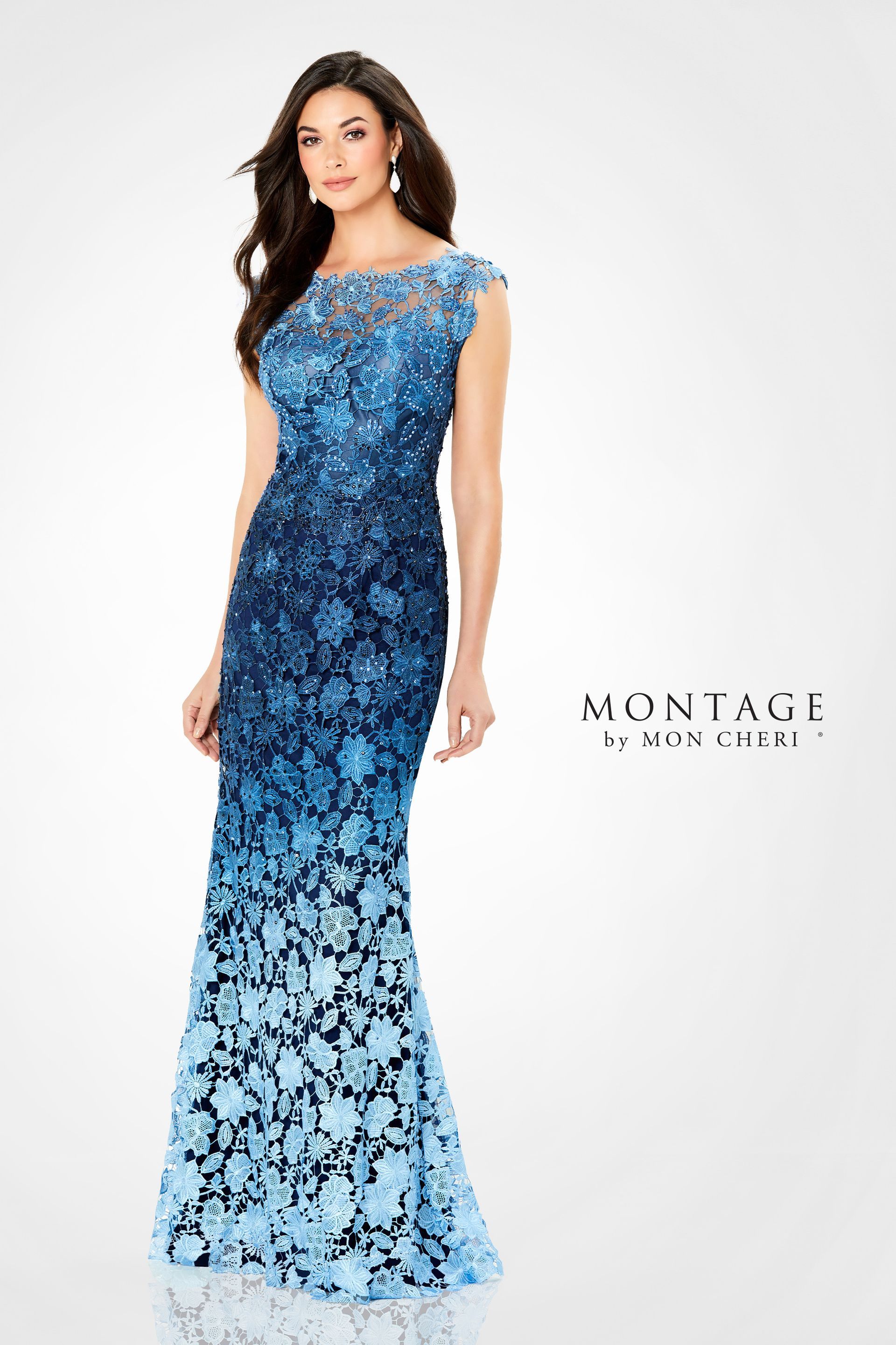 Woman in a gradient blue formal gown, embellished with sequins, posing on a white backdrop.