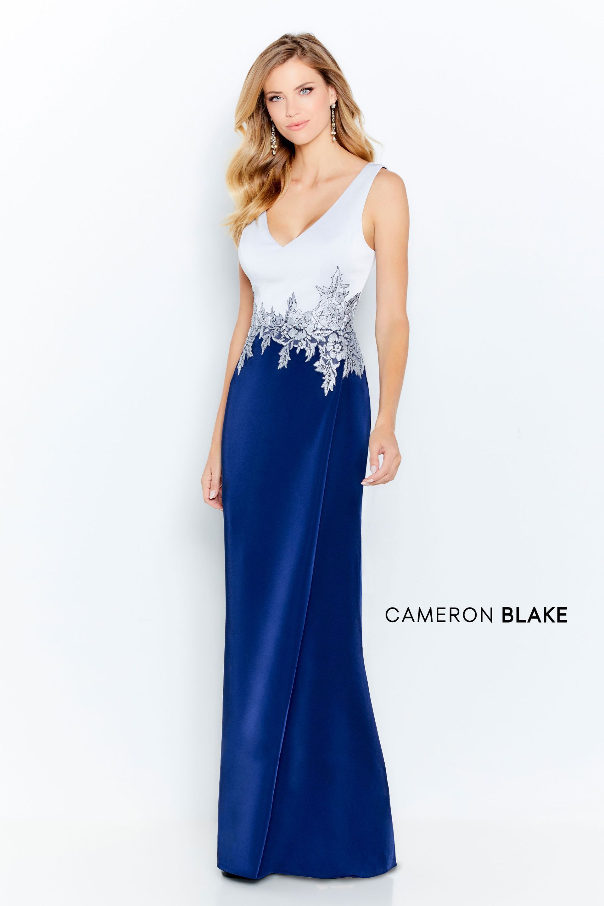 Woman in white-blue gown with floral embellishments.