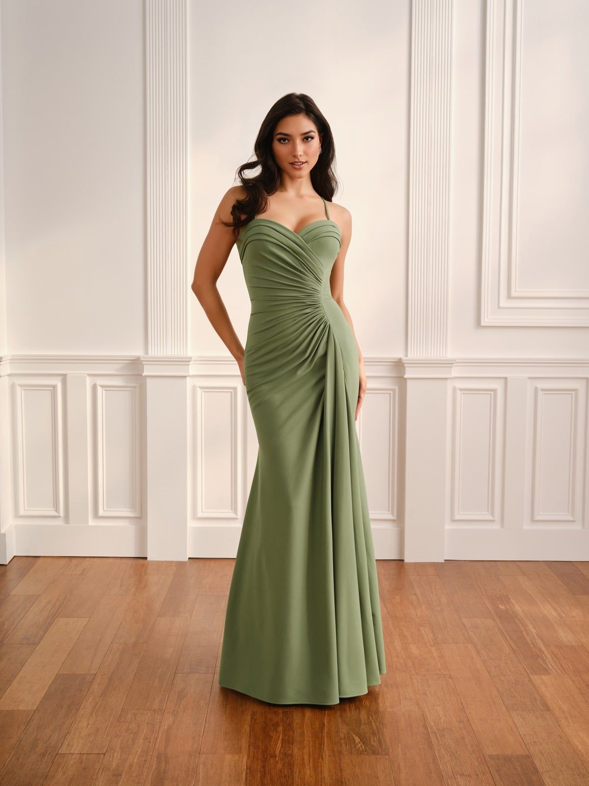 Woman in a magenta strapless gown standing in a white-paneled room with wooden floors.