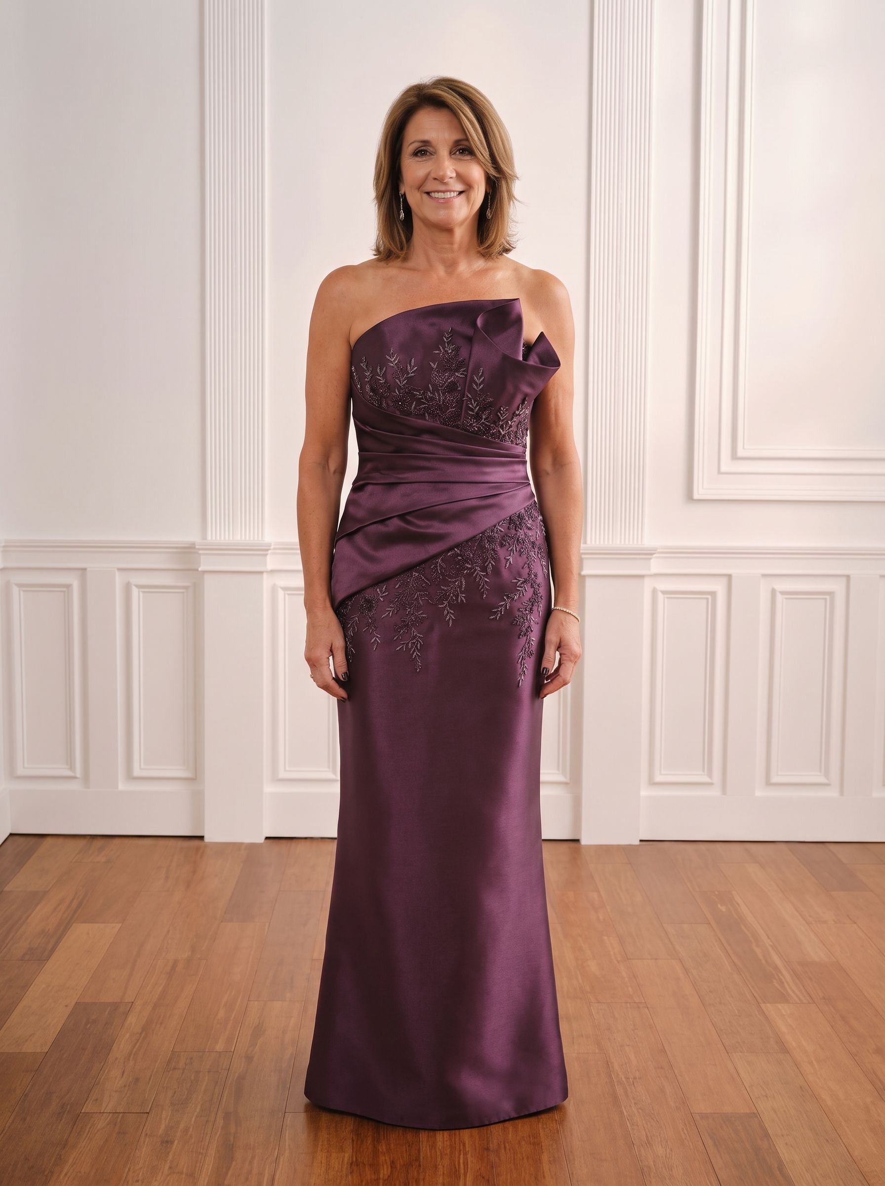 Woman in a gold strapless gown standing in a bright white-paneled room with wood floors