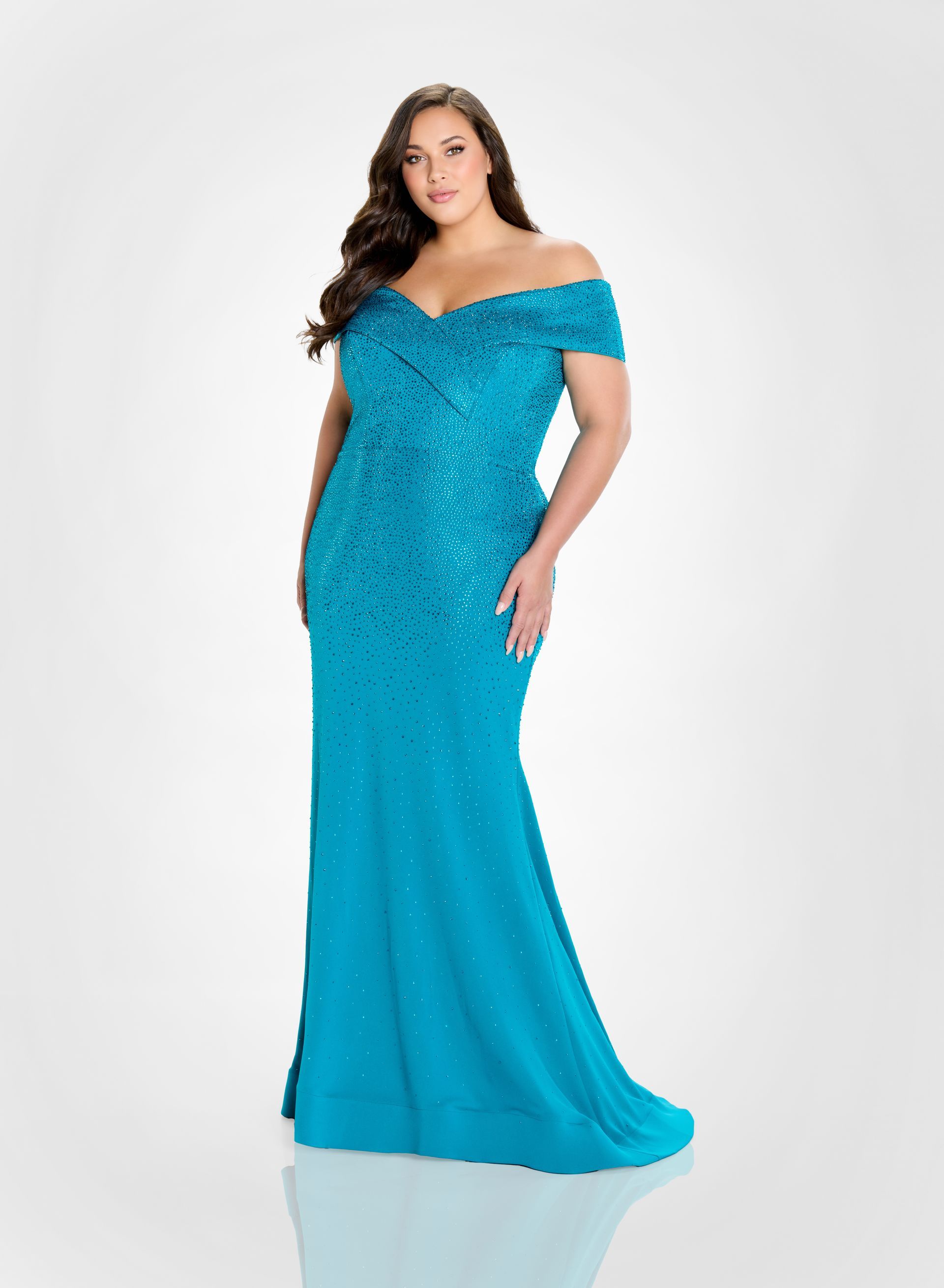 Woman in a navy sequined, off-the-shoulder dress and strappy heels, posing against a white background.