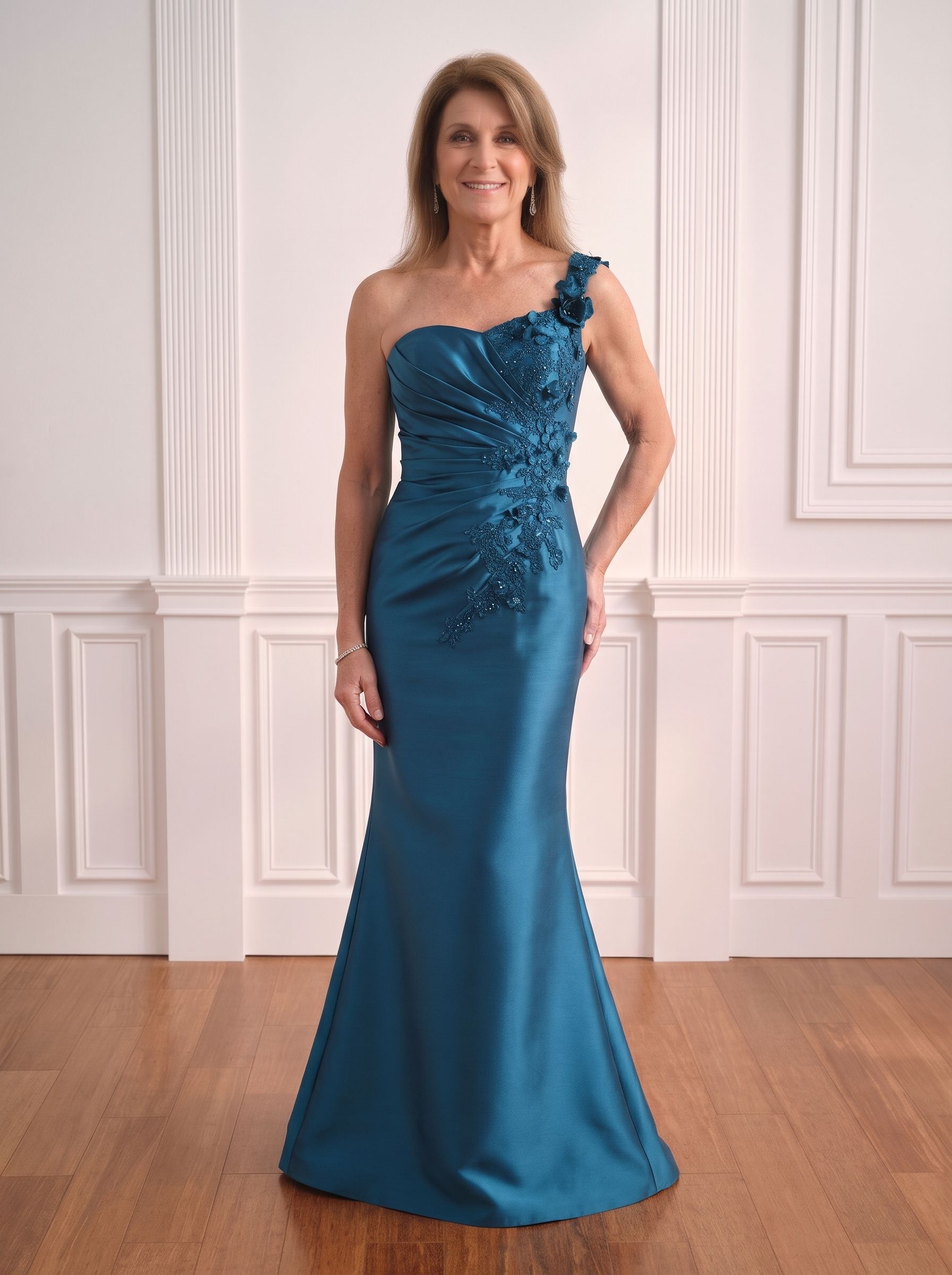 Woman in a teal one-shoulder evening gown standing in a white-paneled room.