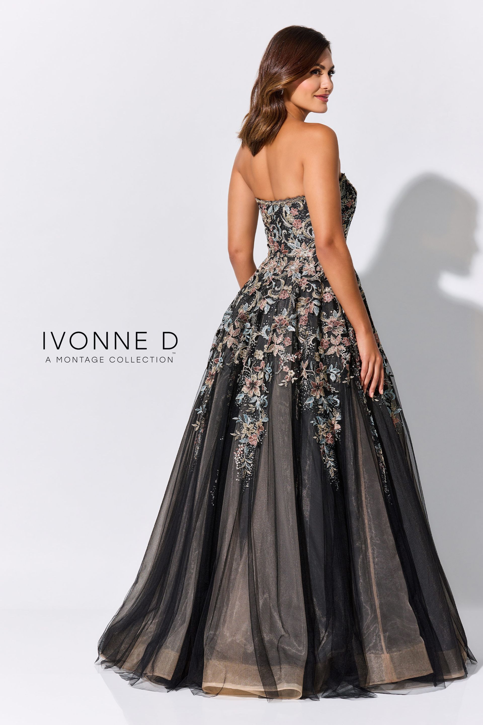 Woman in a strapless black and gold embellished gown, posing against a white background.