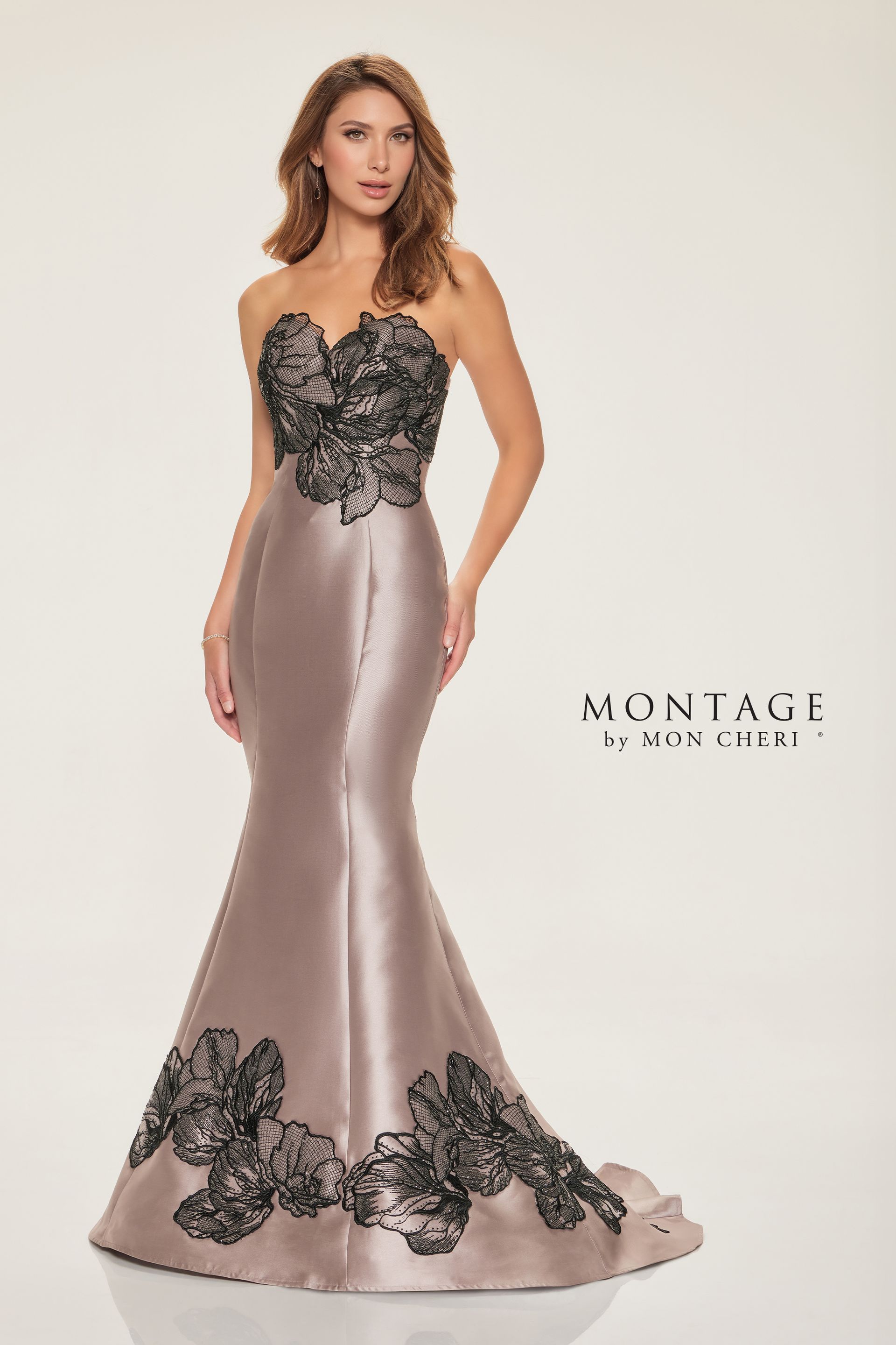 Woman wearing a strapless black-and-silver evening gown with lace details and a mermaid skirt.