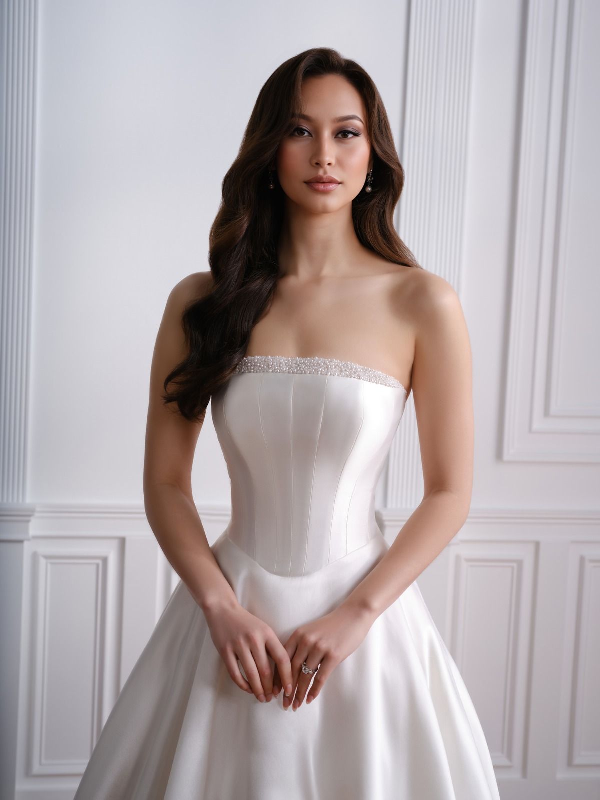 Woman in a strapless white gown standing against a bright paneled wall