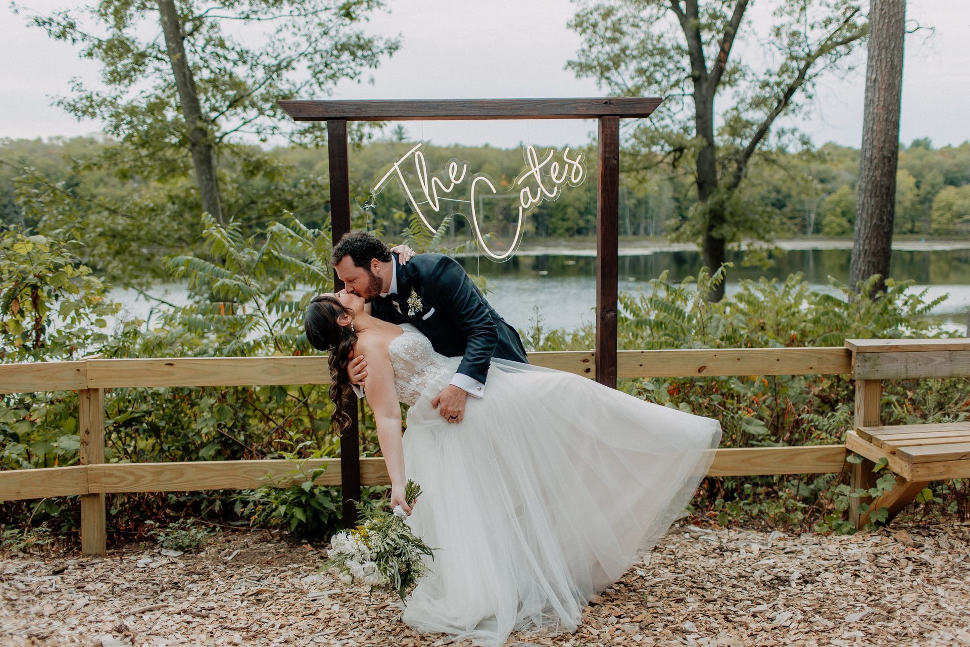 Bride and groom dip near a sign that reads 