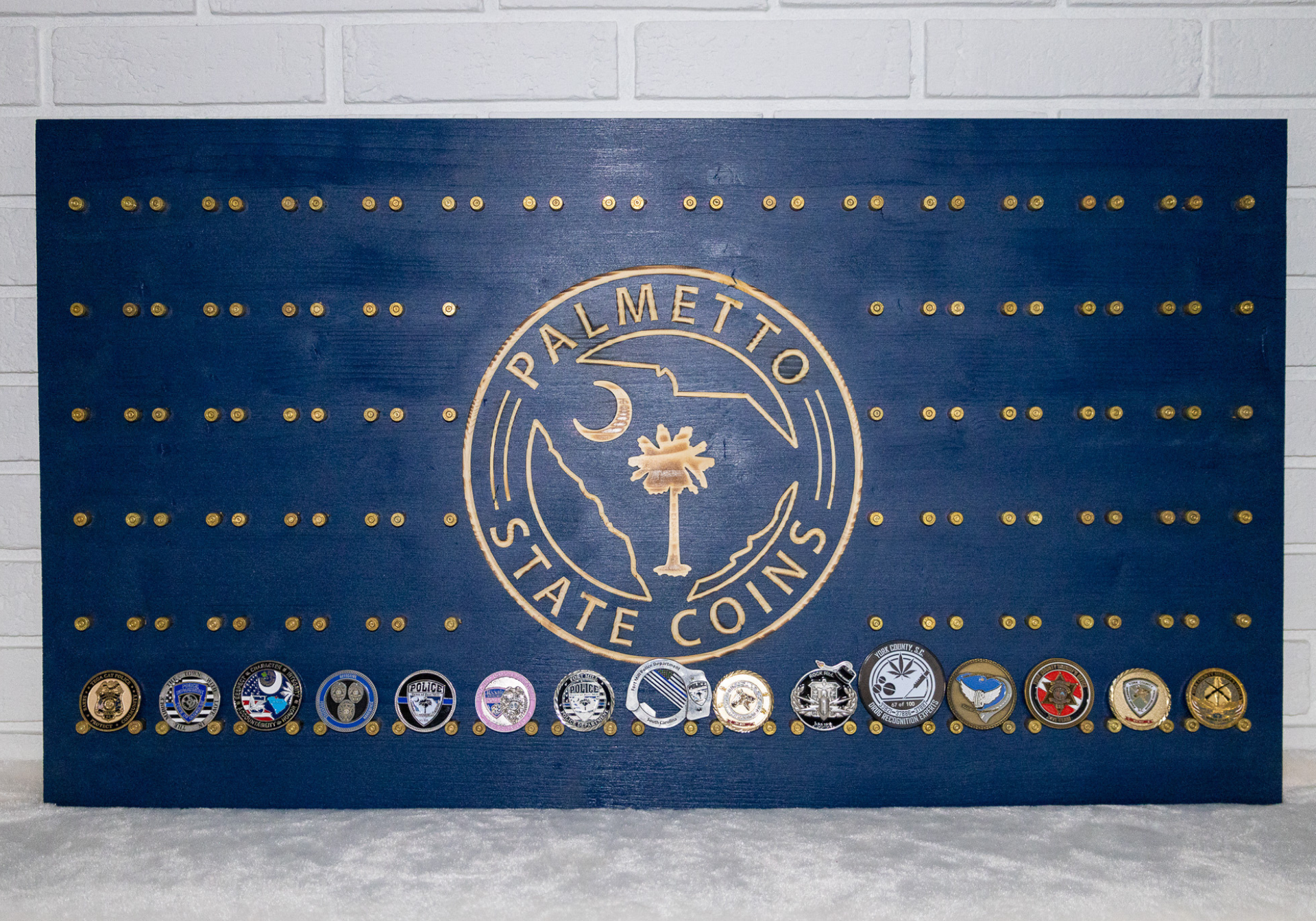 Blue wooden display board with gold accents and coins featuring the Palmetto State logo.