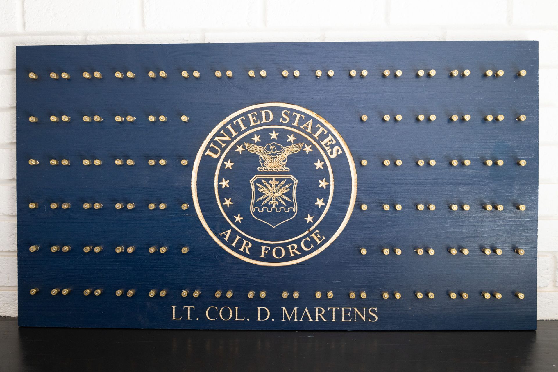 U.S. Air Force plaque with gold emblem and rows of brass nameplates on a blue background