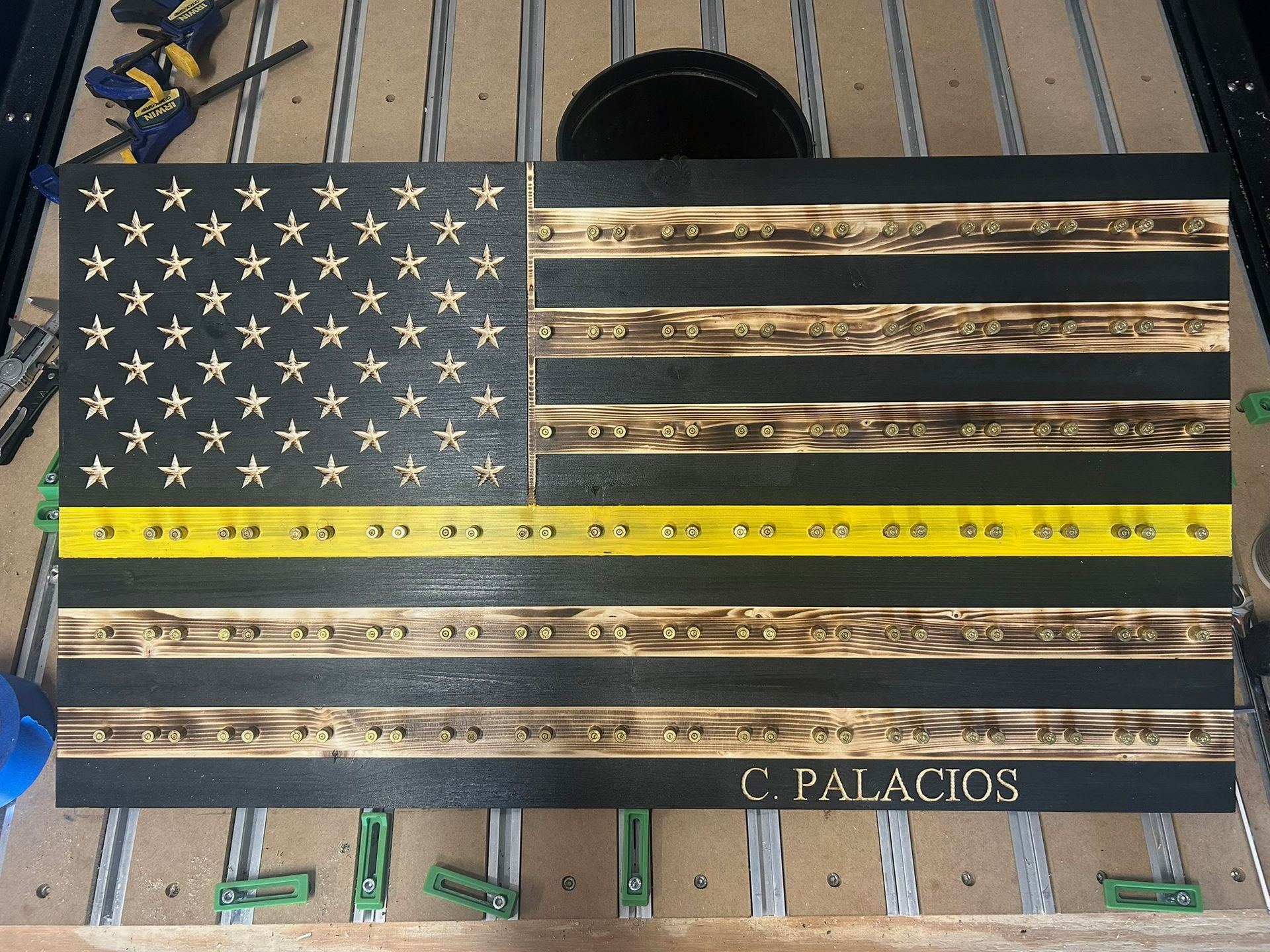 Wooden American flag with a yellow line and engraved text: 