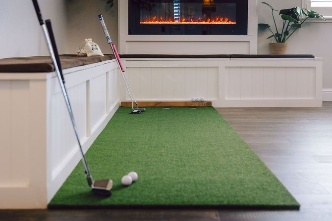 Indoor putting green with two golf clubs and balls in a modern living room