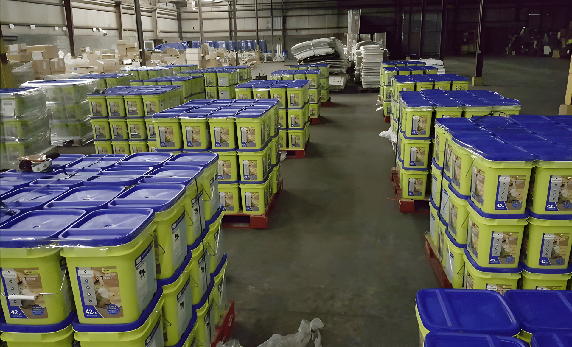 Rows of blue-lidded yellow storage bins in a warehouse aisle