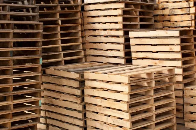Stacked wooden pallets in a warehouse or storage yard
