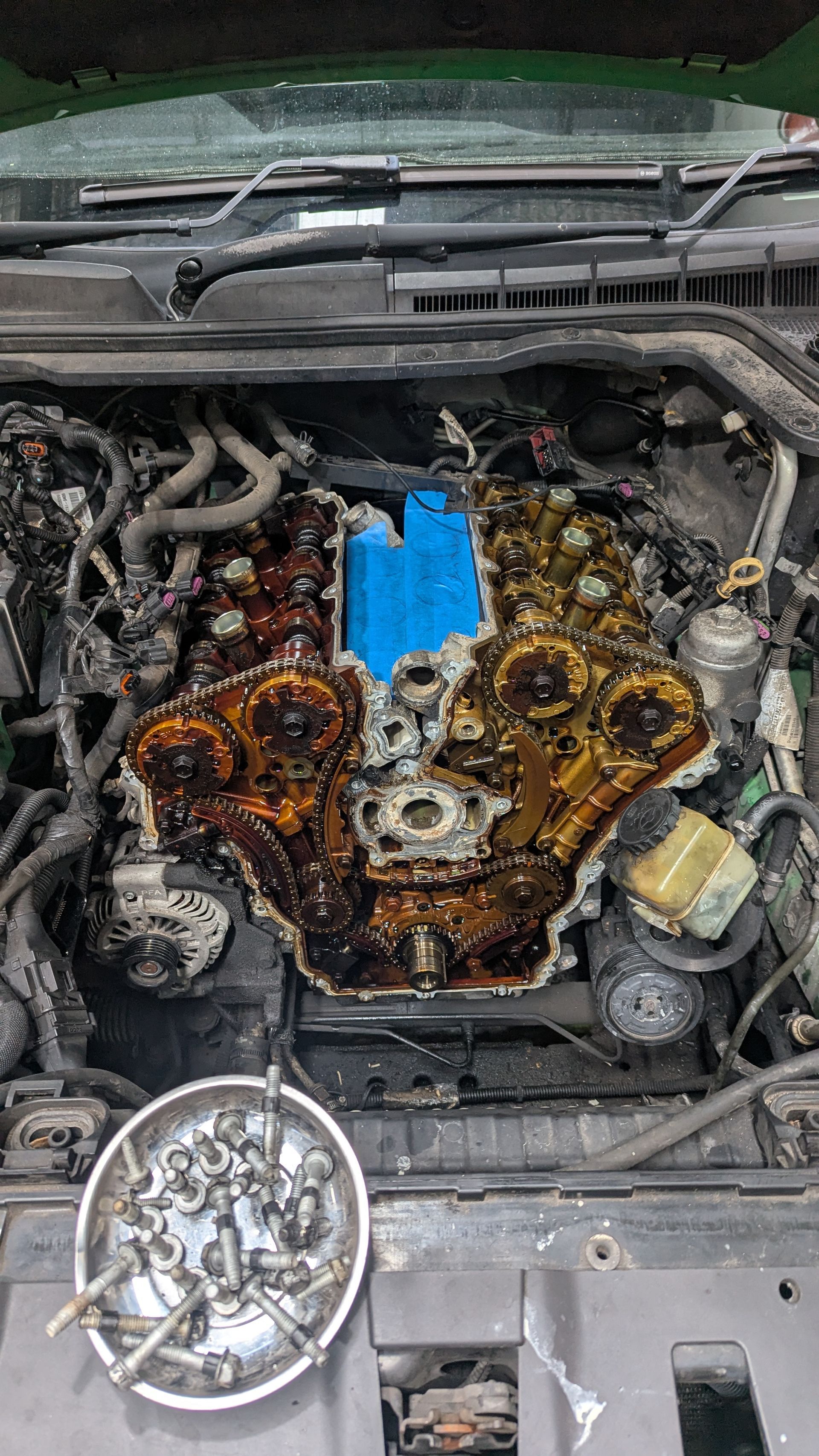 Engine bay with disassembled engine components, showing oil and a blue part — ATD Automotive in North Wollongong, NSW