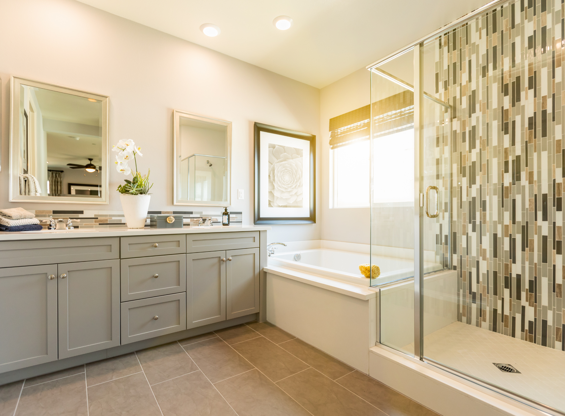A bathroom with two sinks , a tub , and a walk in shower.