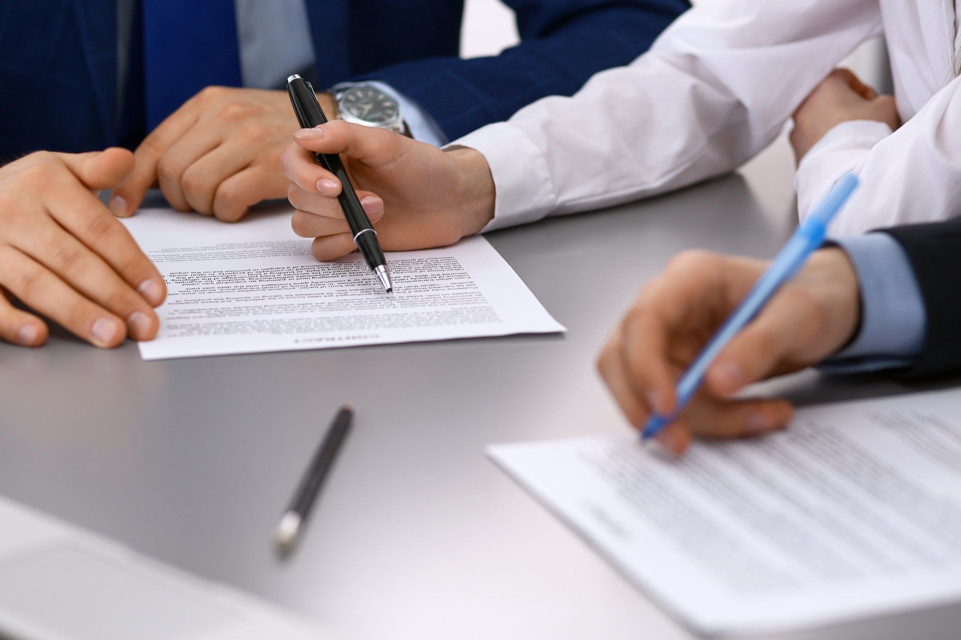 Group of business people and lawyer discussing contract papers sitting at the table