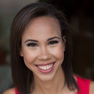 Woman with brown hair smiles, wearing a red top.