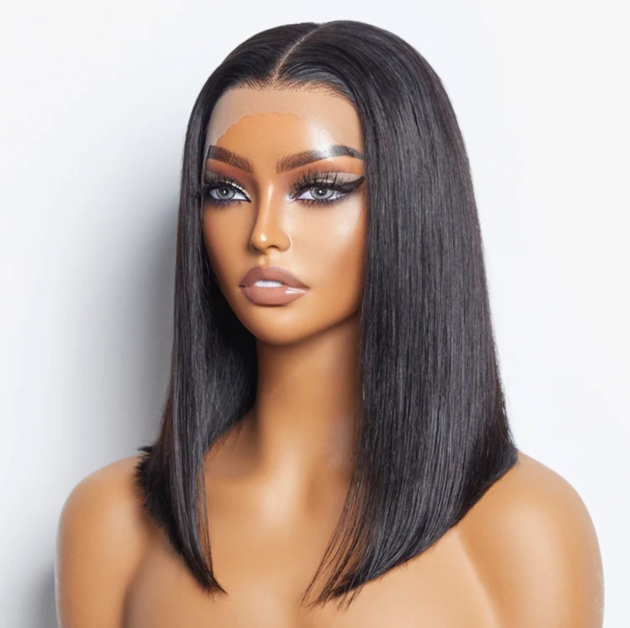 Woman with a dark, straight bob wig, center-parted, posing against a white background.