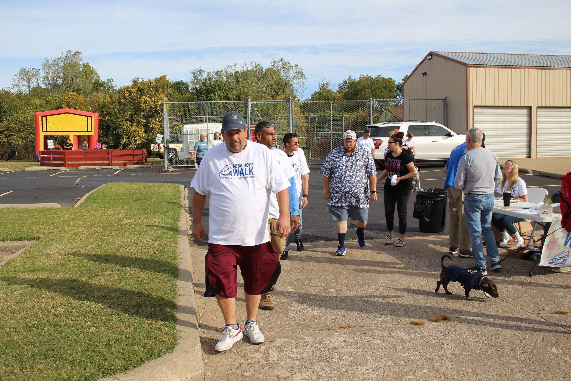 A group of people are walking down a sidewalk with a dog.