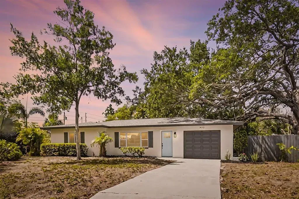 Single-story house with a driveway, garage, and front yard at sunset