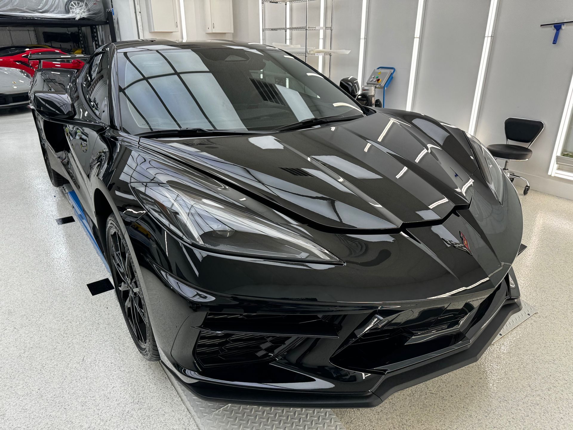 A black sports car is parked in a garage.