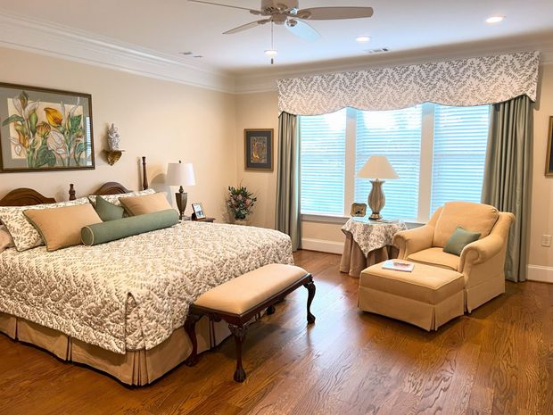 Bright bedroom with a large bed, chaise lounge, and sliding glass doors to a balcony.