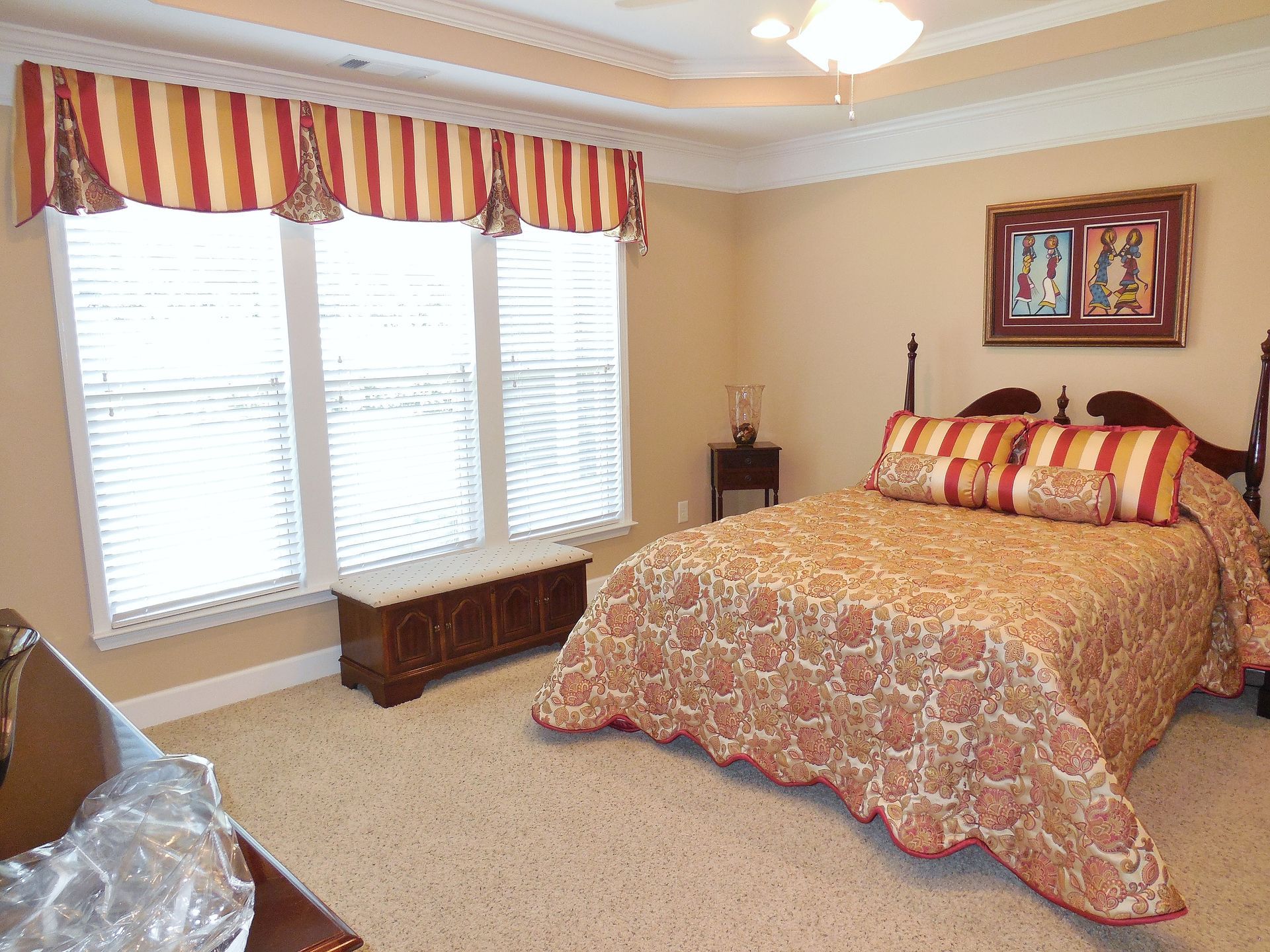 Bedroom with a bed, striped curtains, and windows letting in daylight