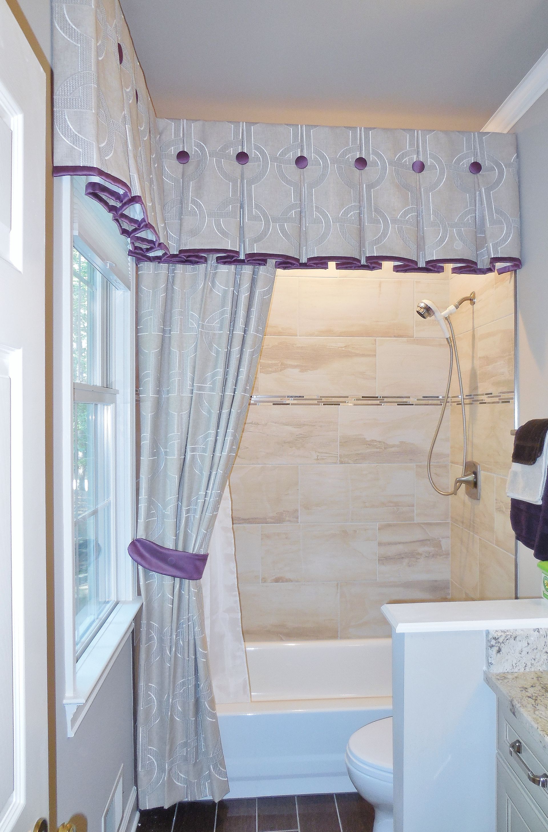Bathroom with shower curtain, window, and bathtub in a small tiled space
