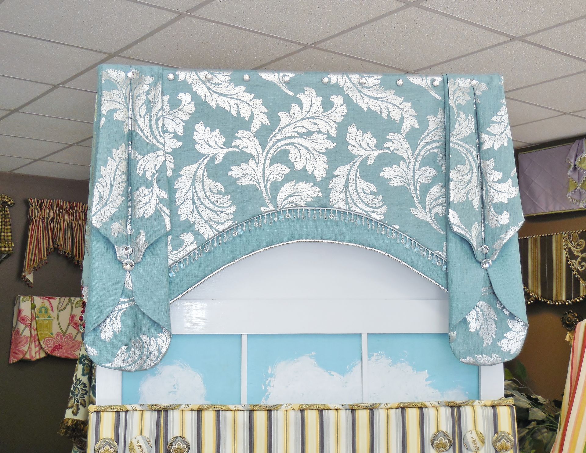 Light blue and white floral drapery over a curved display backdrop in a store interior