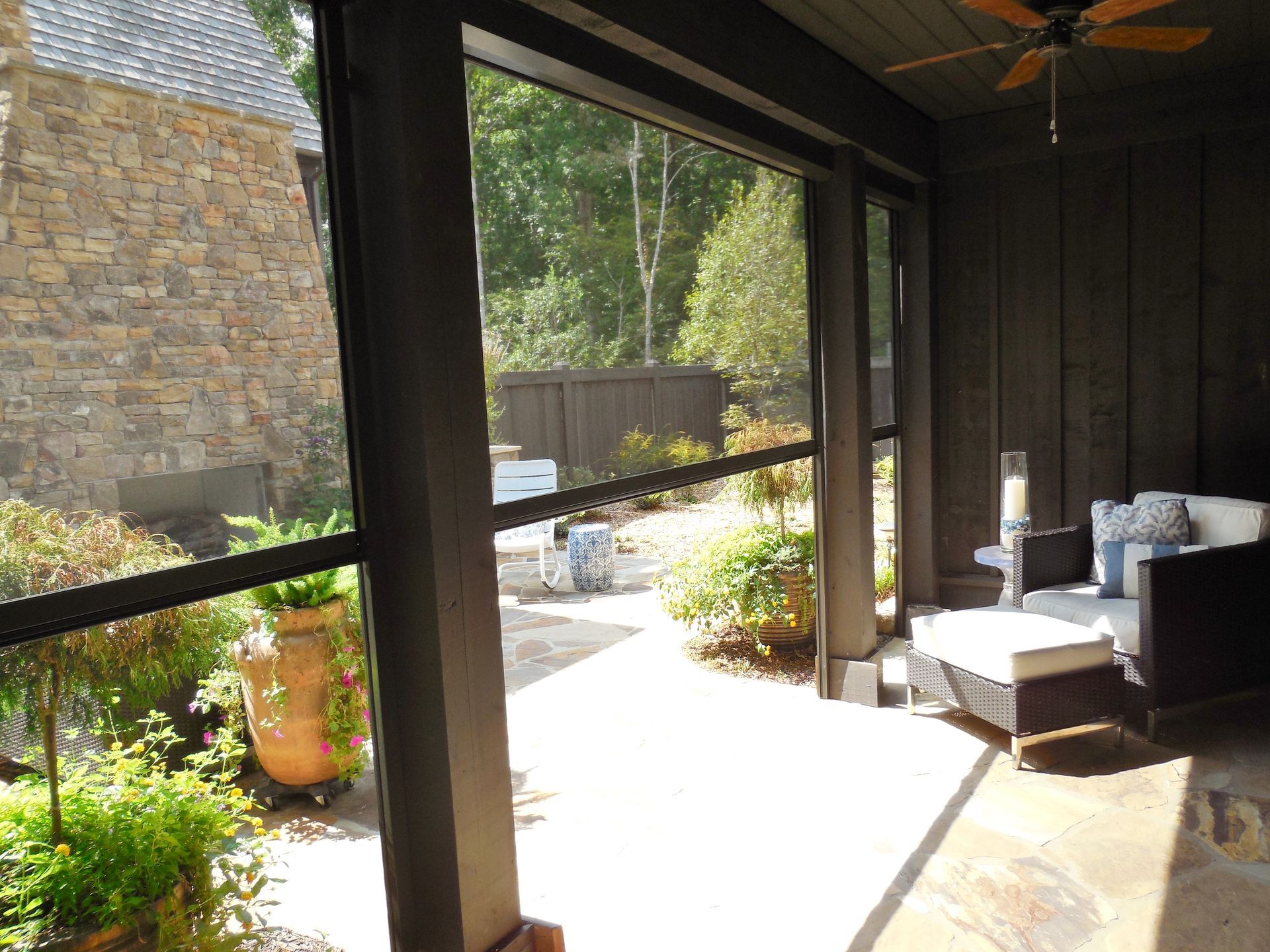 Covered patio with wicker chair and outdoor view through large open sliding doors