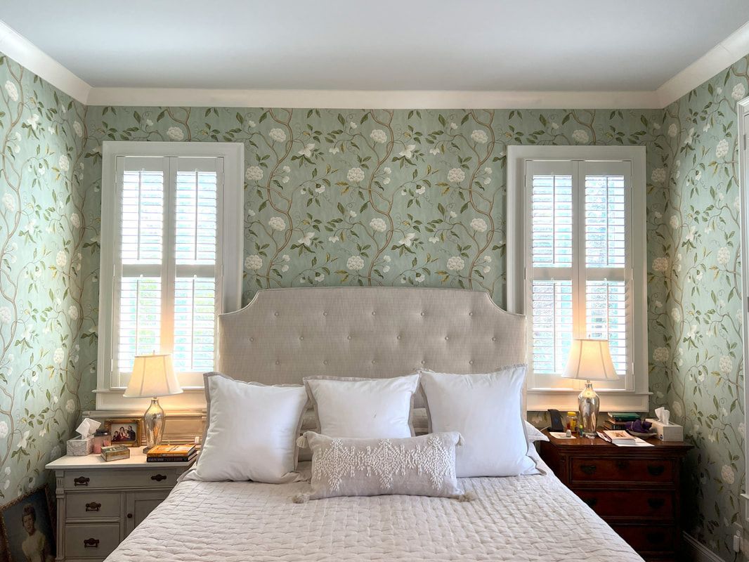 Cozy bedroom with floral wallpaper, tufted bed, and two bedside lamps