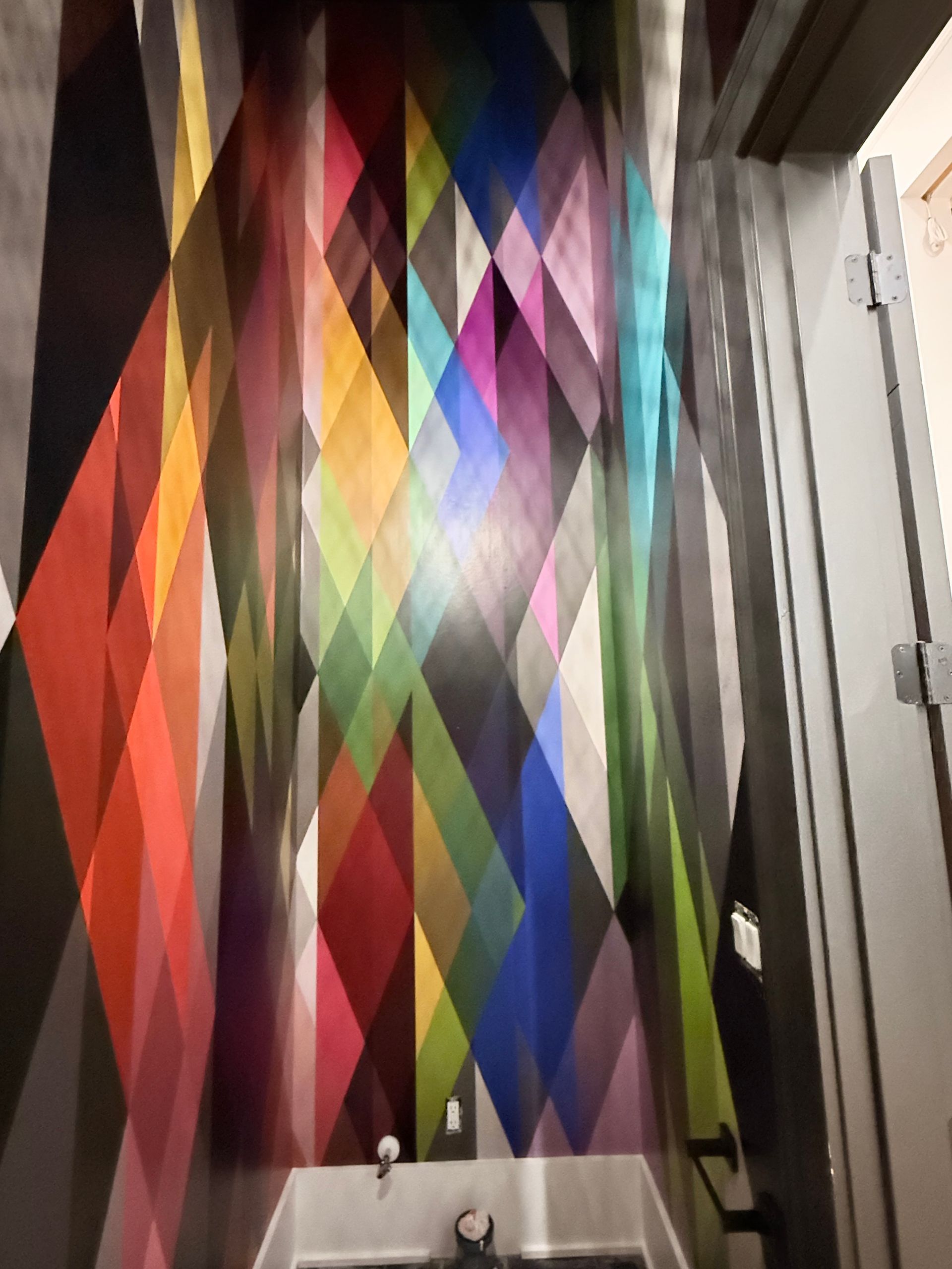 Colorful geometric diamond-pattern curtain hanging in a narrow doorway or hallway