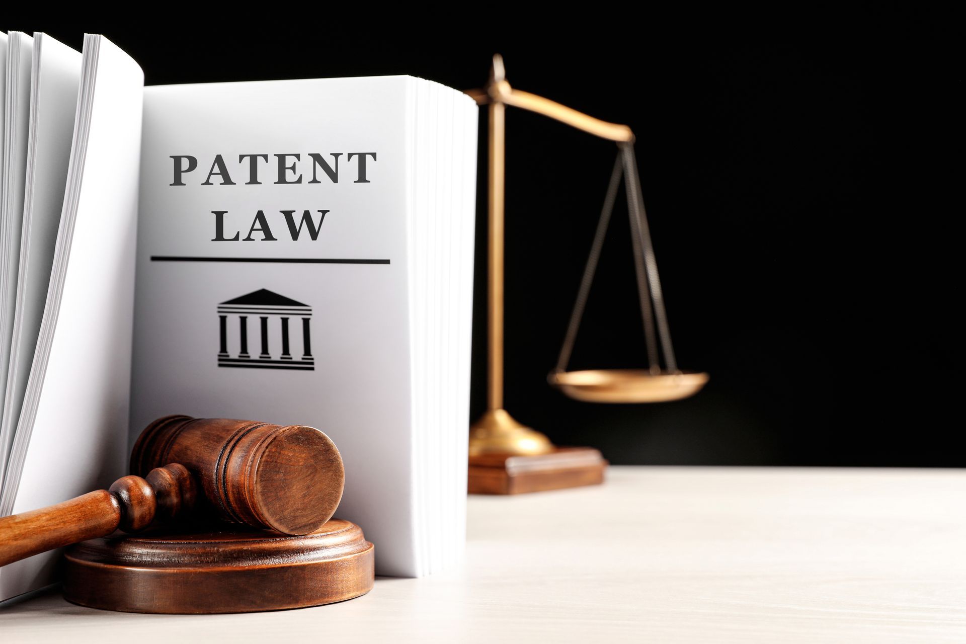 Judge's gavel, Patent Law book and scales on white table