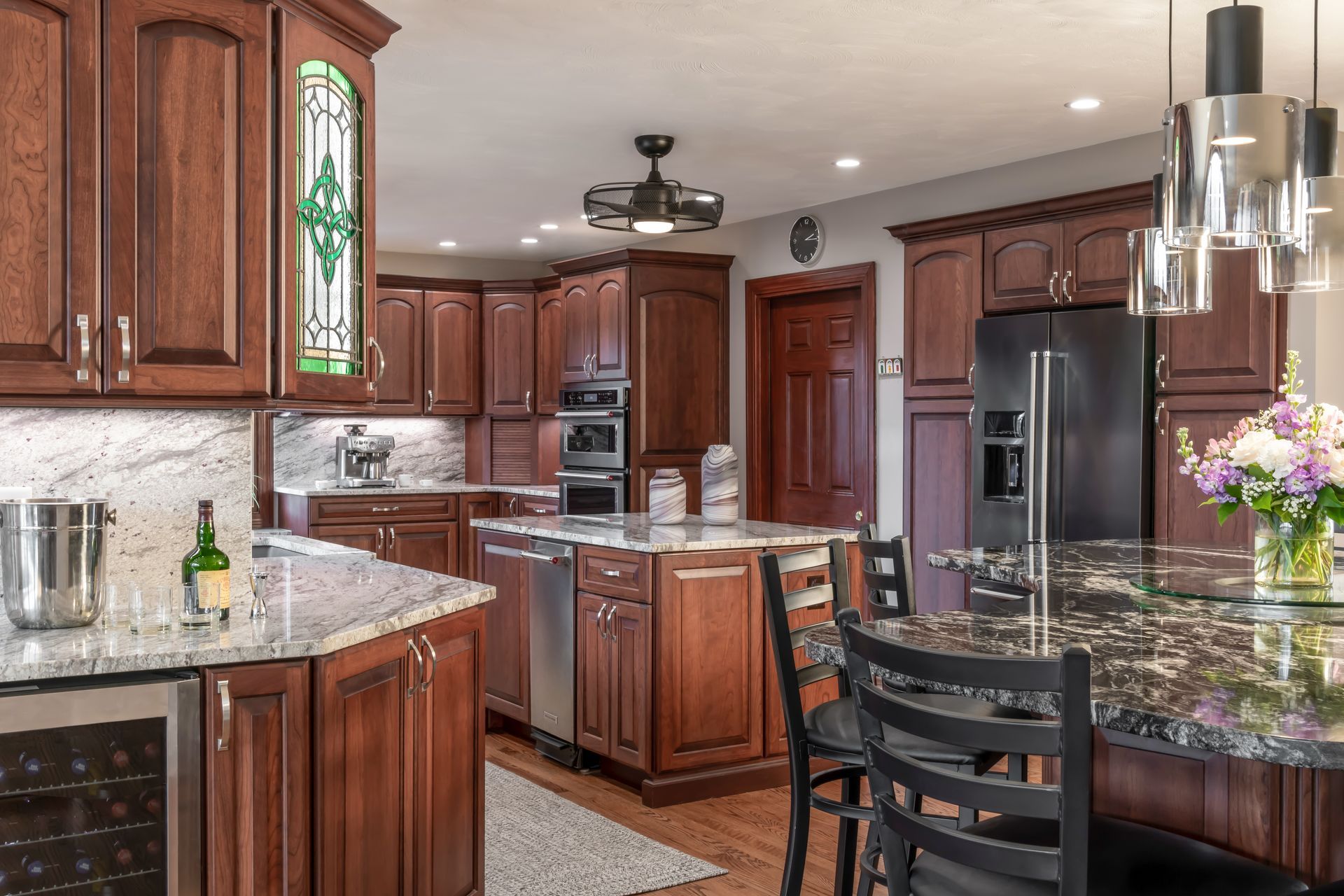 a kitchen with white cabinets , stainless steel appliances , and a large island .