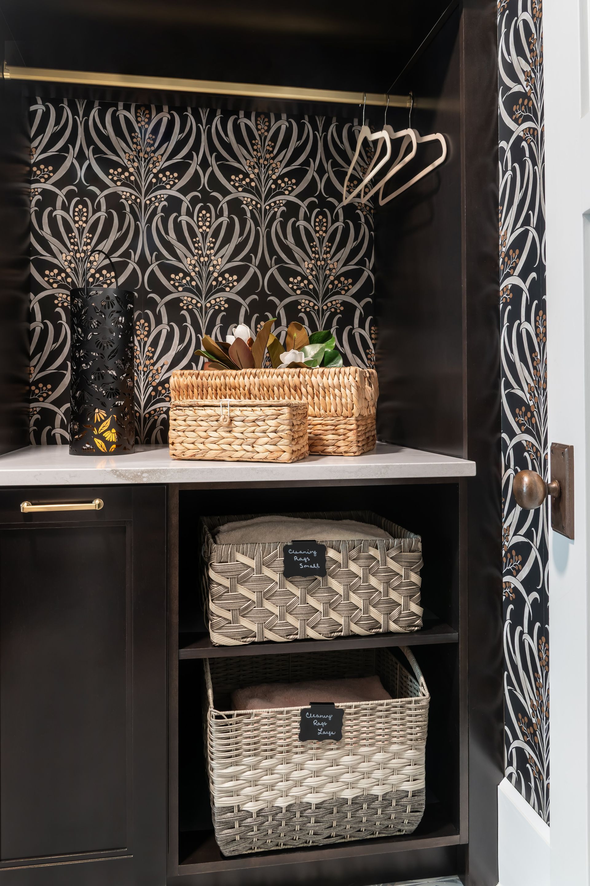A laundry room with wicker baskets and a hanging rack.