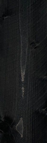 Dark textured surface with vertical streaks and a small worn patch near the center.