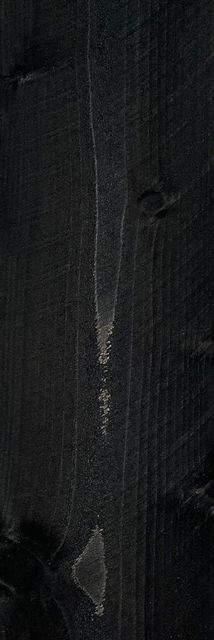 Dark textured fabric with a vertical white scratch or tear near the center and a small frayed mark below