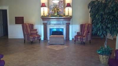Elegant lobby with fireplace, striped armchairs, and a large potted plant