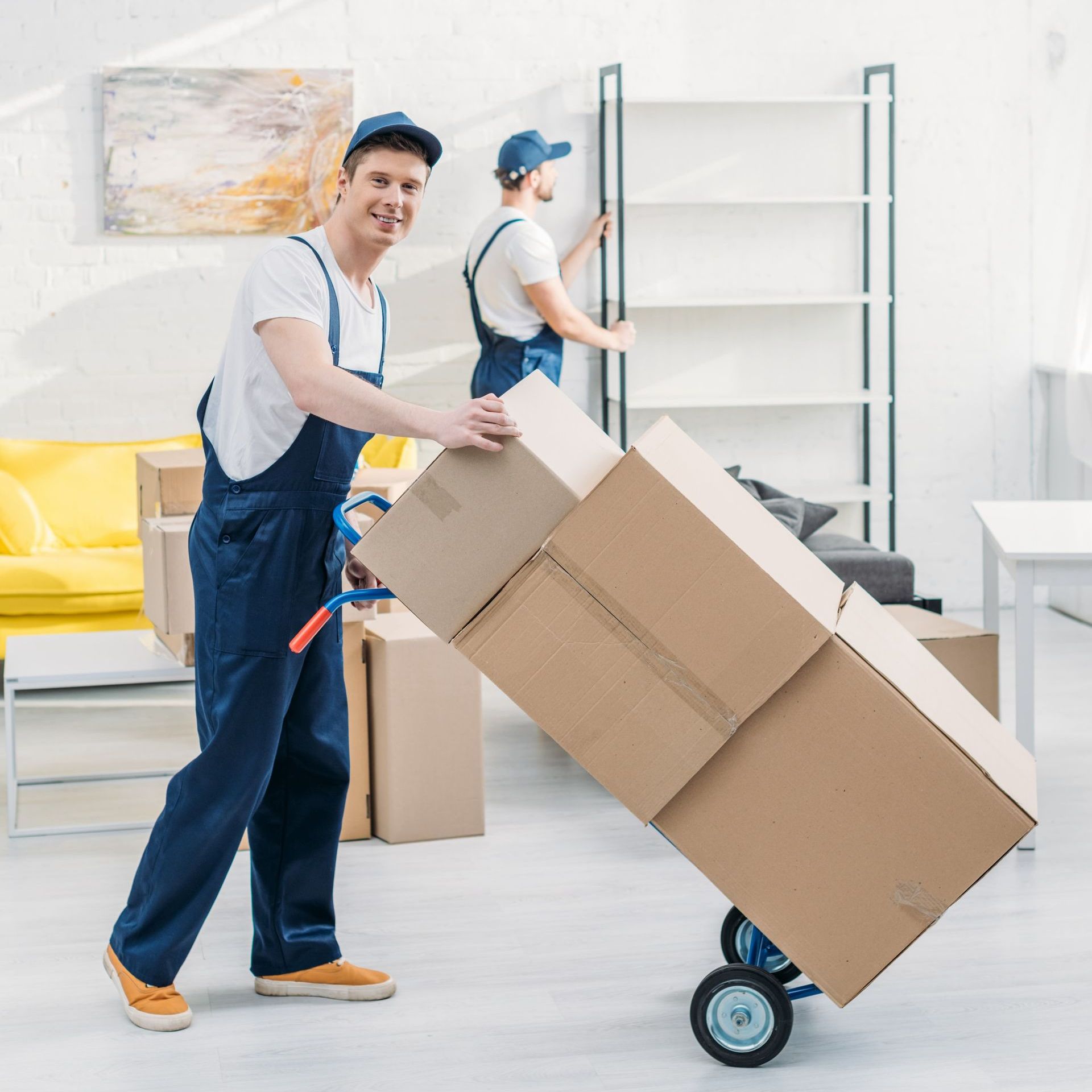 a man is pushing a cart full of cardboard boxes