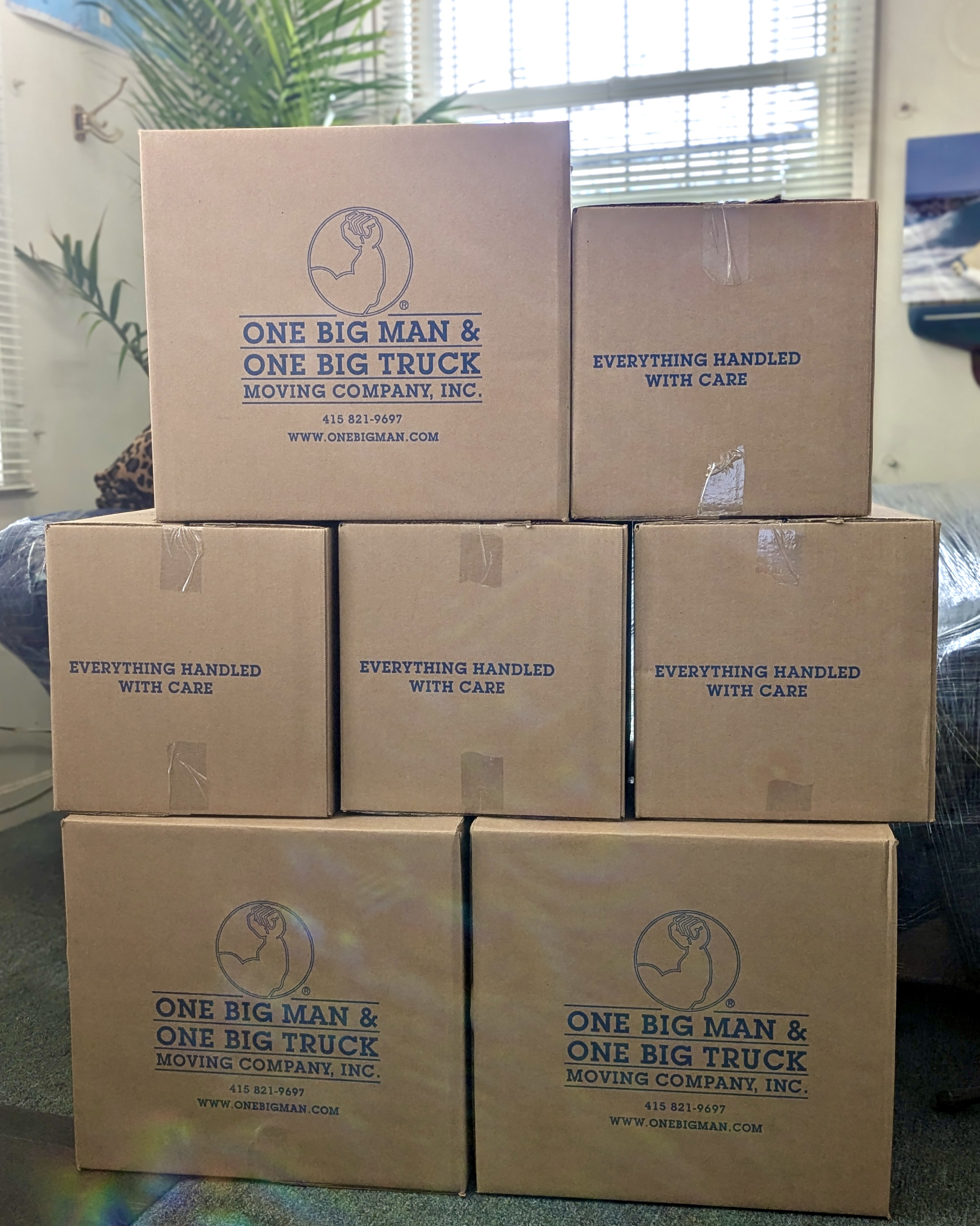 Cardboard moving boxes stacked, some labeled