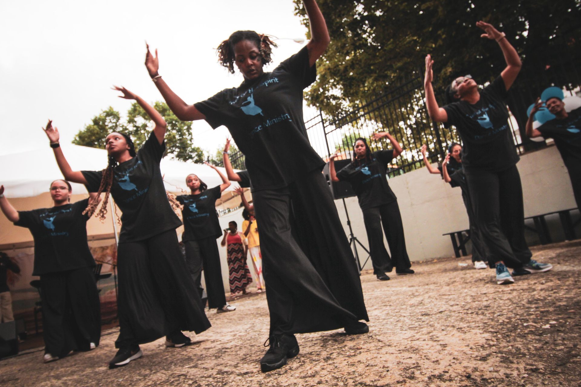 A group of people wearing black shirts with the number 3 on them are dancing