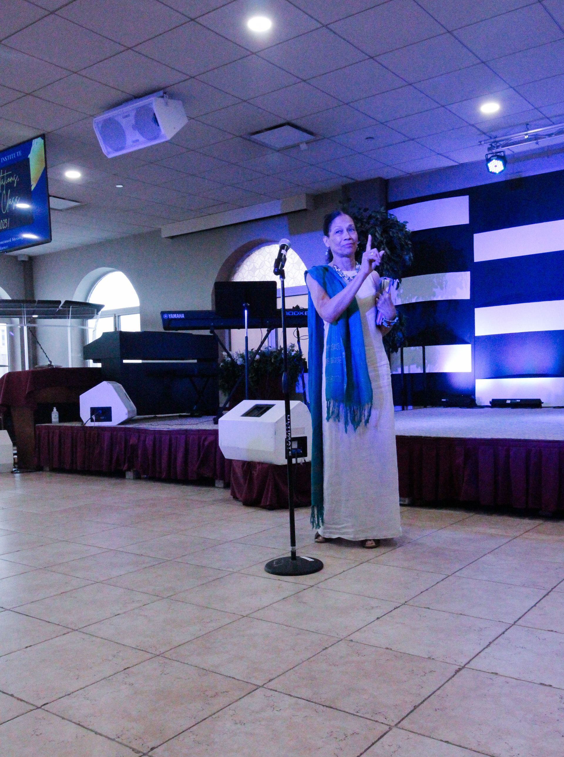 A woman singing into a microphone on a stage