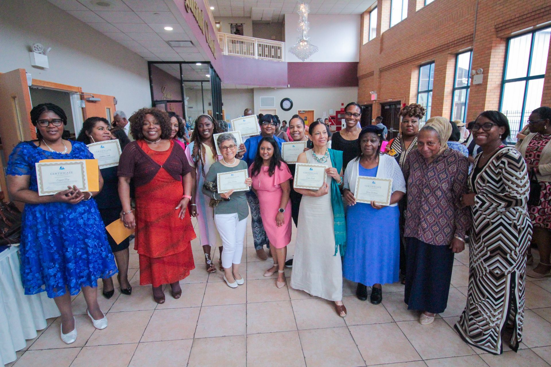 A group of women standing in a room holding certificates