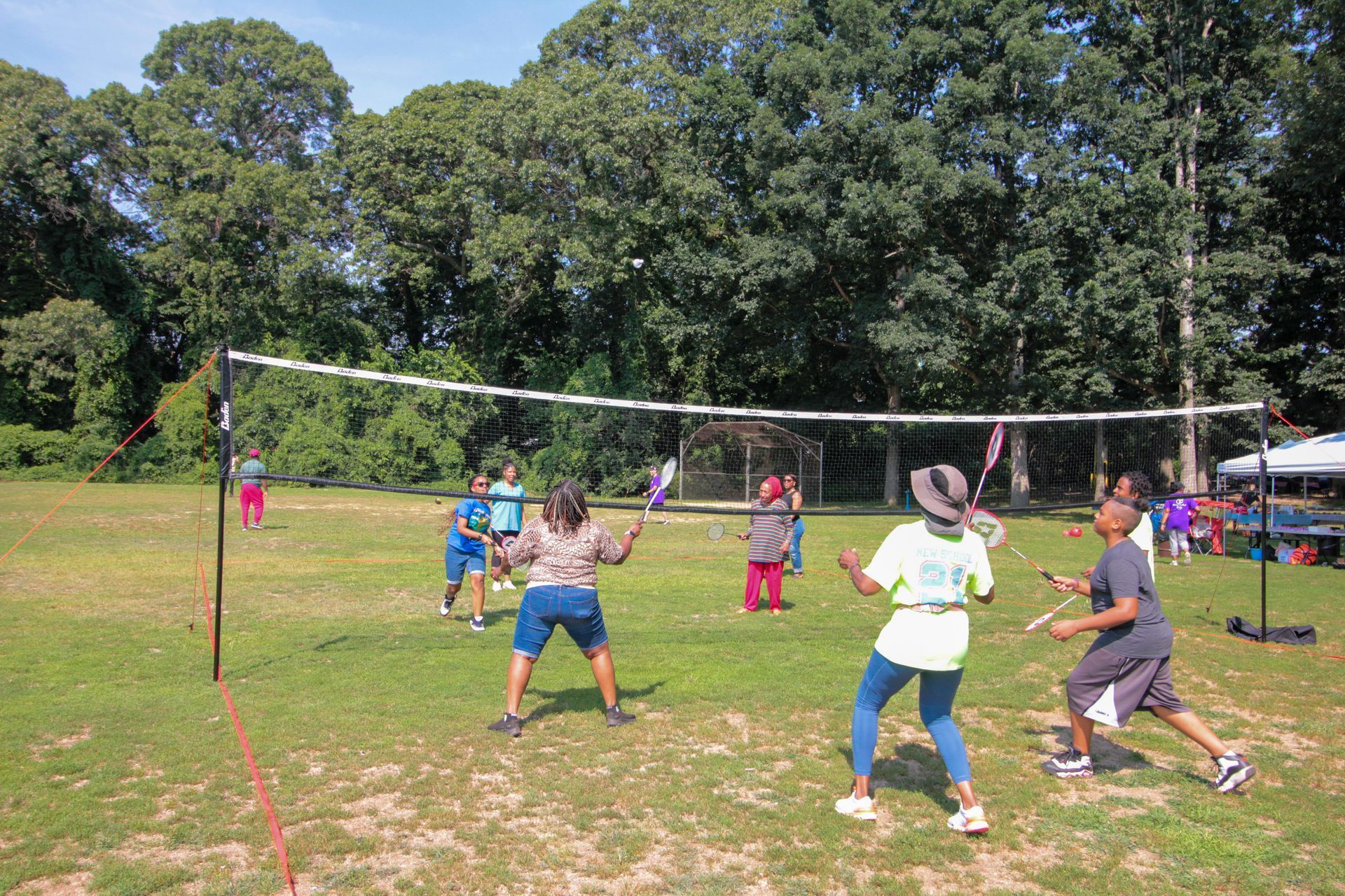 A group of people are playing volleyball in a field.