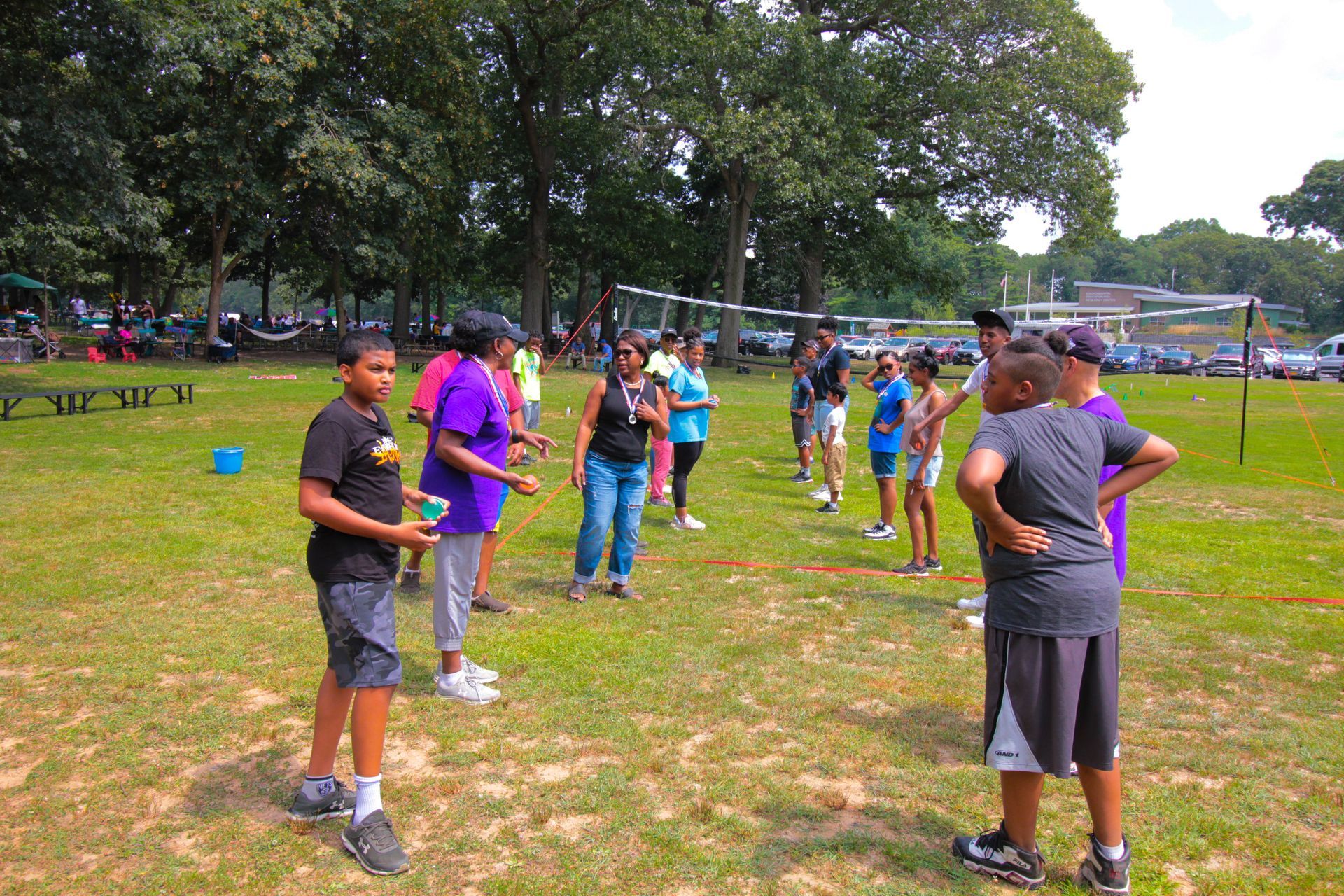 A group of people are standing in a grassy field.